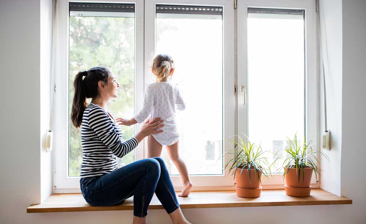 Woman with child in front of window